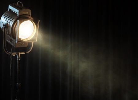 vintage theatre spot light on black curtain with smoke